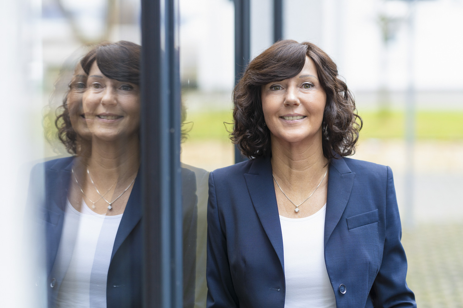 Brigitte Klein, Immobilienmaklerin an Hausfassade