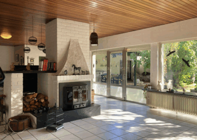 Lichtdurchflutetes Wohnzimmer mit Blick auf die überdachte Terrasse – stilvolle Verbindung von Innen- und Außenbereich