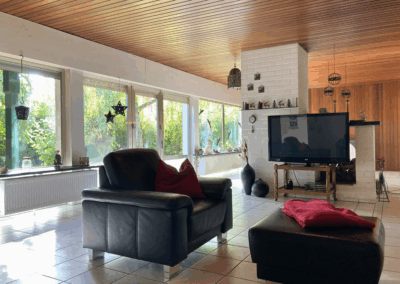 Wohnzimmer im Einfamilienhaus in Alterkülz mit großem Fenster und direktem Blick in den Garten – heller Wohnbereich mit Verbindung zur Natur