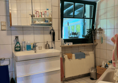 Bild des Badezimmers im Obergeschoss mit Waschbecken, Badewanne und Fenster zur Gartenseite