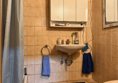 Bild des kleines Badezimmers im Erdgeschoss mit Waschbecken, Dusche und WC