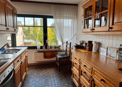 Küche mit großen Fenstern und Blick in den Vorgarten – heller und funktionaler Kochbereich mit Tageslicht