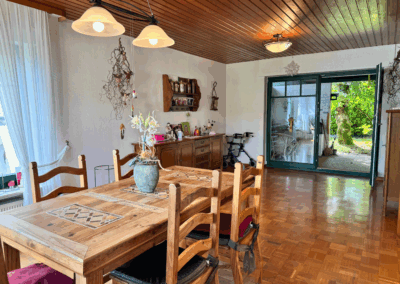 Bild des großen Esszimmers mit Parkettboden und direktem Zugang zur Terrasse – heller Wohnbereich mit Außenbezug