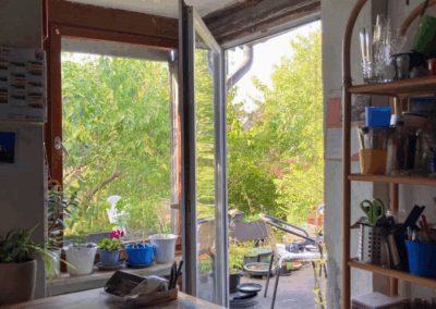 Blick von der Küche durch die Terrassentür auf die Terrasse und in den Garten