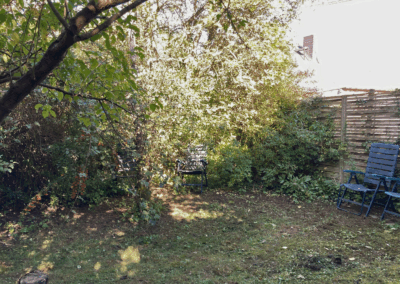 Bild vom Garten hinter dem Haus mit geschütztem Platz für mögliche Sitz- und Grillecke