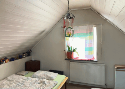 Bild des ausgebauten Dachbodens mit Fenster zur Straßenseite und Schlafbereich