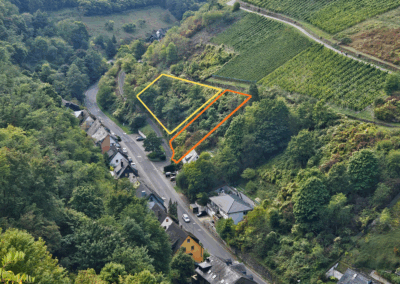 Ansicht der Grundstücke aus der Distanz – das Baugrundstück ist in orange und das angrenzende Naturgrundstück in gelb eingezeichnet. Die Lage ist gut erkennbar, eingebettet in die umgebende Landschaft
