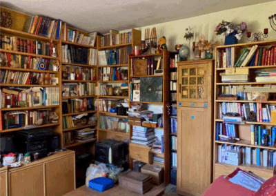 Wohnzimmer mit durchgängigen Bücherregalwänden an zwei Seiten, Sofa und Couchtisch