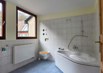 Geräumiges Badezimmer des Studios im Dachgeschoss mit Eckbadewanne, WC und 2 Fenstern