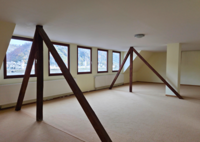 Studio im Dachgeschoss mit dunklen Holzbalken und Blich auf den Rhein und St. Goarshausen