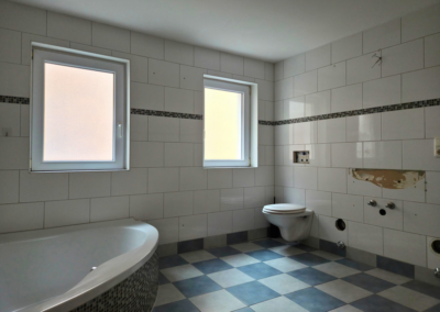 Bad der Wohnung im 1. Obergeschoss mit Eckbadewanne, WC und 2 Fenstern. Das Waschbecken fehlt.